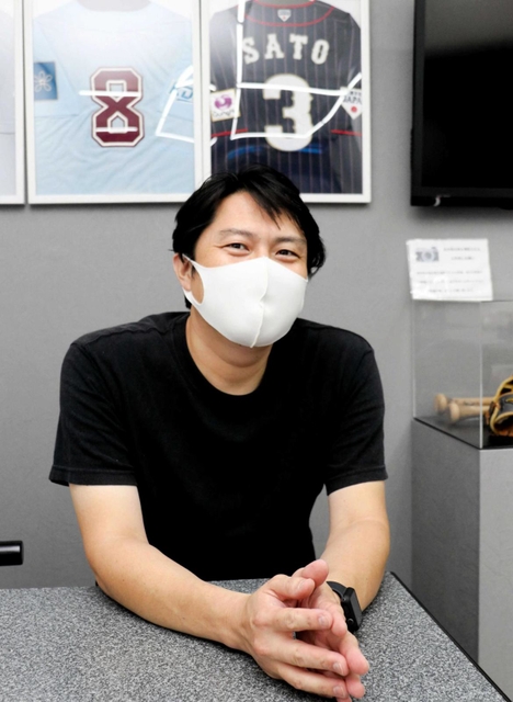 阪神・佐藤輝の“ファン第１号”の高取君己さん。自身が営む飲食店に贈られたユニホームなどを飾る＝西宮市荒木町、「はづき」