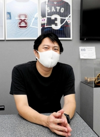 阪神・佐藤輝の“ファン第１号”の高取君己さん。自身が営む飲食店に贈られたユニホームなどを飾る＝西宮市荒木町、「はづき」