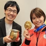 淡路屋名物「ひっぱりだこ飯」の特製“金のふた”を受け取り、と金メダルと一緒に掲げる東京五輪金メダリストの阿部詩選手（右）＝神戸新聞社（撮影・鈴木雅之）