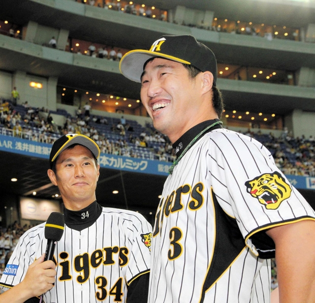 久保康友投手に感謝の言葉をかけられ照れ笑いの関本賢太郎内野手＝阪神甲子園球場（２０１１年）