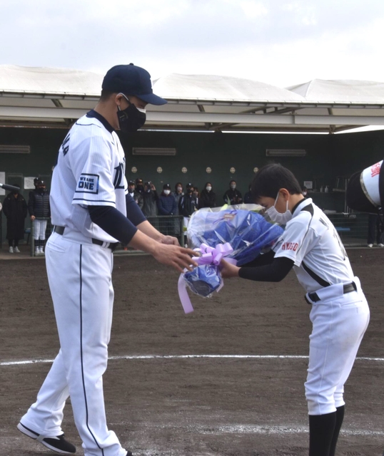 通算２千安打達成のお祝いとして、選手から花束を受け取る西武・栗山（左）＝三木市、三木総合防災公園野球場