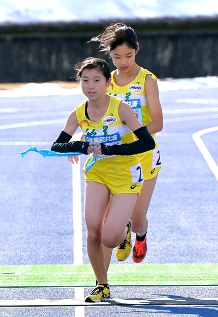 女子・稲美の３区吉川陽菜（奥）からたすきを受け取り走り出す４区湊友希（撮影・秋山亮太）