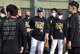 母校・育英高野球部の同級生らに記念品を贈られ、笑顔を見せる西武・栗山（中央）＝三木市、三木総合防災公園野球場