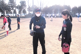 シオノギ製薬の選手（中央）から教わる参加者＝浜田球場（県ソフトボール協会提供）