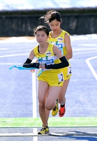 女子・稲美の３区吉川陽菜（奥）からたすきを受け取り走り出す４区湊友希（撮影・秋山亮太）