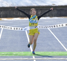 両手を突き上げ、笑顔でフィニッシュする女子稲美のアンカー藤田直子選手＝１９日午前、滋賀県希望が丘文化公園（撮影・秋山亮太）