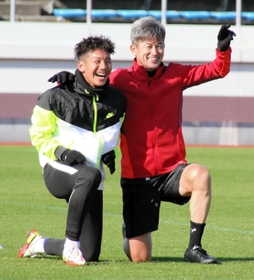 トレーニングの合間、Ｇ大阪の井手口陽介とカメラに向かって笑顔でポーズを取る横浜ＦＣの三浦知良＝１２月１５日、大阪府内
