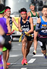 男子・西脇工の１区長嶋幸宝（左）からたすきを受け、駆け出す２区山中達貴（中央）＝２６日、京都市内（撮影・中西幸大）