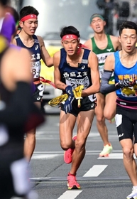 男子・西脇工の１区長嶋幸宝（左）からたすきを受けて駆け出す山中達貴（中央）＝撮影・中西幸大