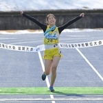 両手を突き上げ、笑顔でフィニッシュする女子稲美のアンカー藤田直子選手＝１９日午前、滋賀県希望が丘文化公園（撮影・秋山亮太）