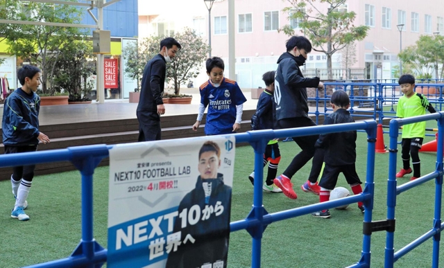 サッカースクールの開校記念イベントで子どもたちとボールを蹴る堂安憂さん（右から３人目）。指導メニューは弟で日本代表の律と考案した＝尼崎市、あまがさきキューズモール