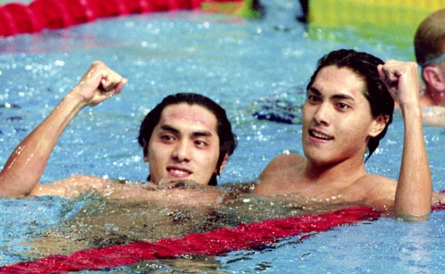 バンコク・アジア大会男子１００メートル自由形で優勝し、ガッツポーズする伊藤俊介（左）と２位に入った双子の弟、秀介＝１９９８年１２月９日、タイのタマサート・プ-ル