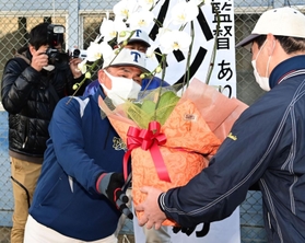 選抜出場を決め、花鉢を手渡される東洋大姫路・藤田明彦監督（左）＝２８日午後、姫路市打越の同校グラウンド（撮影・中西幸大）