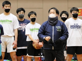 練習で本間雄二コーチ（右から３人目）の話を聞くゴッドドアの選手＝西宮市内