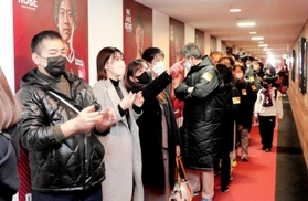 名選手の写真やユニホームが飾られた「レジェンドウォーク」を歩く、スタジアムツアーの参加者たち＝ノエビアスタジアム神戸