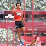 東京五輪陸上男子走り幅跳び決勝で日本の橋岡優輝の踏み切りを確認する坂部雄作さん（右端）＝２０２１年８月２日、国立競技場