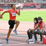 東京五輪陸上男子走り幅跳び決勝で日本の橋岡優輝の踏み切りを確認する坂部雄作さん（右端）＝２０２１年８月２日、国立競技場