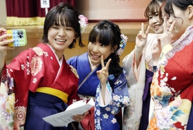 卒業式で、友人と共に写真に納まるフィギュアスケート女子の三原舞依（中央）＝神戸市東灘区、甲南大（撮影・長嶺麻子）