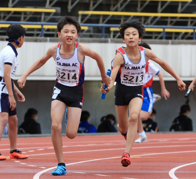 小学男子４００メートルリレー決勝　但馬ＡＣの３走川見光（右）からバトンを受け取るアンカー南光海翔＝ユニバー記念競技場（撮影・吉田敦史）