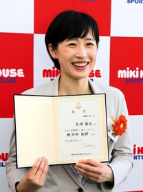 辞令を手に笑顔を見せる馬淵優佳＝大阪府八尾市のミキハウス本社