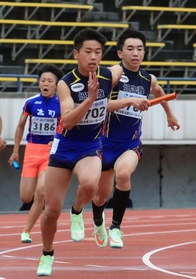 中学男子４００メートルリレー決勝　姫路灘の３走藤尾晃大（右）がアンカー村瀬翔汰にバトンをつなぐ（撮影・吉田敦史）