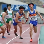高校男子１６００メートルリレー決勝　３走富山涼太からバトンを受けて駆け出す姫路のアンカー高見陸亜（中央）＝ユニバー記念競技場（撮影・小林良多）