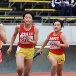 小学女子４００メートルリレー決勝　加古川ＲＣの３走納庄晴夏（右）がアンカー藤原瞭希にバトンをつなぐ＝ユニバー記念競技場（撮影・吉田敦史）