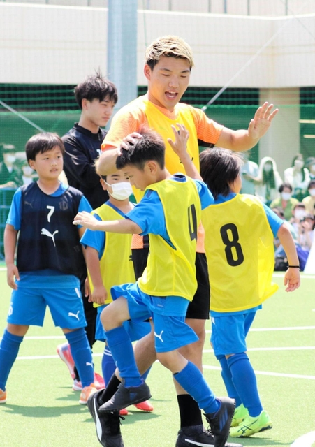 ゴールを決めた子どもを出迎える堂安律＝尼崎市、ＲＤフィールド