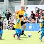子どもたちに囲まれながらドリブルを仕掛ける堂安律＝尼崎市、ＲＤフィールド