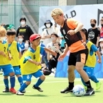 子どもたちに囲まれながらボールをキープする堂安律＝尼崎市、ＲＤフィールド