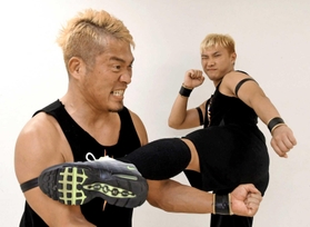 望月ジュニア選手（右）から蹴りを受ける望月マサアキ選手＝神戸市中央区浜辺通５、神戸サンボーホール