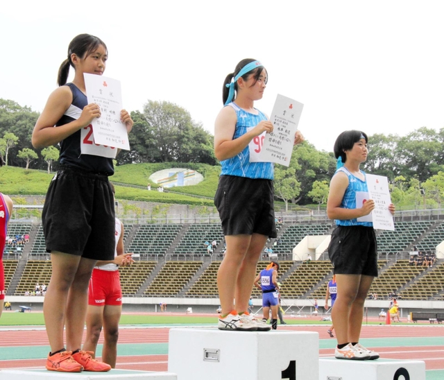 女子２年砲丸投げで優勝し、表彰台に立つ姫路女学院の永井彩花（中央）