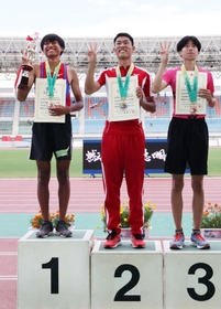 陸上男子走り高跳びで２メートル１２をマークし、表彰式でトロフィーを手に笑顔を見せる市尼崎の川崎俊祐（左）＝７日、徳島県鳴門市、鳴門ポカリスエットスタジアム（撮影・長嶺麻子）