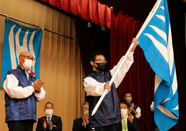 兵庫県選手団を代表して県旗を受け取った陸上の中川龍一＝神戸市中央区、県民会館
