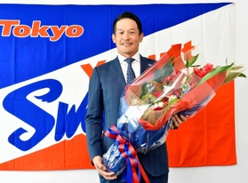 現役引退の記者会見で花束を手に笑顔を見せるヤクルト・坂口＝30日、神宮（代表撮影）