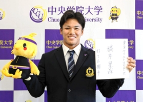 ヤクルトの担当スカウトから指名挨拶を受け橋本星哉。入団する意向を示し「打てる捕手」と抱負を誓った＝２６日午後、千葉県我孫子市の中央学院大（大学提供）