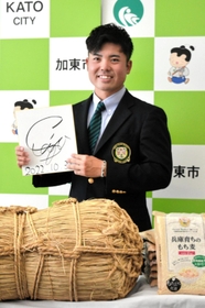 地元加東市の特産品を贈呈され、サイン色紙を手に記念写真に納まる蟬川泰果＝３１日午前、加東市社、加東市役所