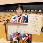 小中高の全国大会や国際大会で贈られた賞状やメダルを手にするボウリング女子の石田万音＝神戸市中央区、ラウンドワン三宮駅前店