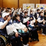 拳を突き上げ、健闘を誓う選手ら＝神戸市中央区、県民会館