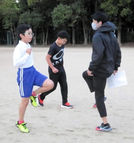 山陽特殊製鋼陸上部のコーチや選手らから指導を受ける小学生＝姫路市飾磨区中島