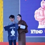 キン肉マンとのコラボレーションＴシャツを持つ山崎道洋さん（左）とブータン柔道協会のカルマ・ドルジ会長＝ブータン・ティンプー（ブータン柔道協会提供）