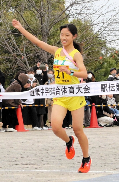 ２連覇を飾り、右手を上げてフィニッシュする女子・稲美のアンカー吉川陽菜＝奈良県橿原市運動公園