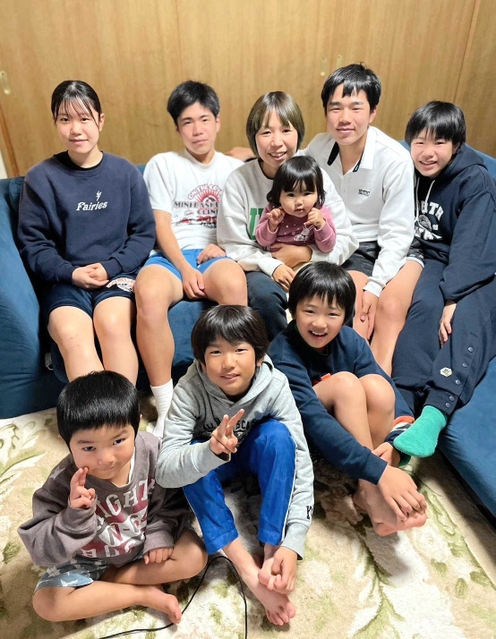 ８人のわが子と写真に納まる宮城佳代子さん（後列中央）。後列右端は次女の美海選手＝神戸市北区（提供）