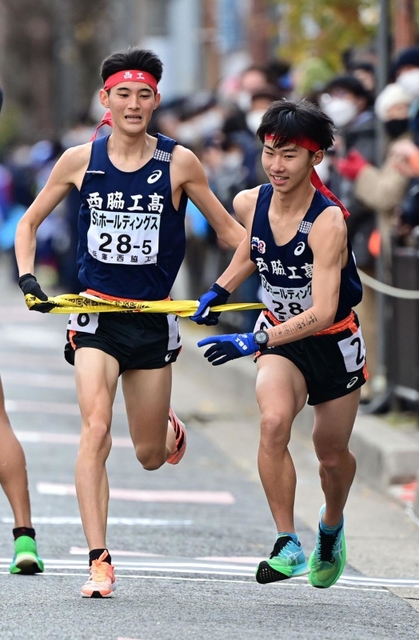 男子・西脇工の５区稲見峻（左）からたすきを受ける６区江上天晴＝京都市内