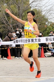 ２連覇を飾り、右手を上げてフィニッシュする女子・稲美のアンカー吉川陽菜＝奈良県橿原市運動公園