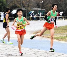 男子・稲美北　５区山口朔門（右）からたすきを受け取り走り出す６区八嶋純平＝奈良県橿原市運動公園