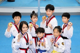 ３兄妹の野谷昊雅さん（後列右から２人目）、芽愛さん（同３人目）、絆心君（前列中央）ら全国大会のメダリスト７選手＝神戸市兵庫区中道通６