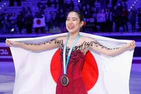 フィギュアスケート・ＧＰファイナルの女子で初出場優勝を果たし、日の丸を広げる三原舞依＝10日、イタリア・トリノ（共同）