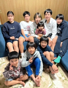 ８人のわが子と写真に納まる宮城佳代子さん（後列中央）。後列右端は次女の美海選手＝神戸市北区（提供）