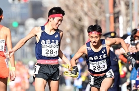 男子・西脇工の１区長嶋幸宝（左）からたすきを受け、駆け出す２区小田伊織